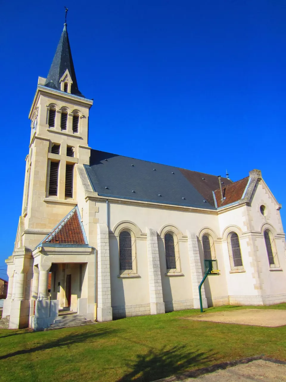 Küçük bir Fransız köyünde taş duvarlı, çan kuleli bir kilise