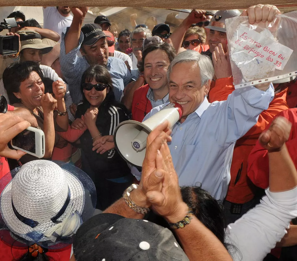 Sebastián Piñera elinde madencilerin notunu tutuyor